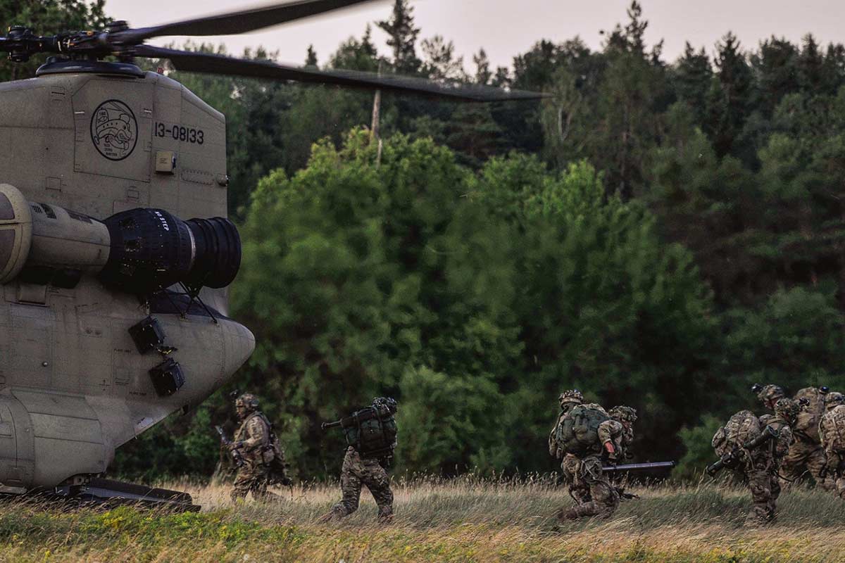 Soldiers running out of the back of a chinook helicopter